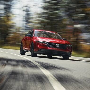 2026 Honda Accord driving in a forest environment taking the curve of the road.